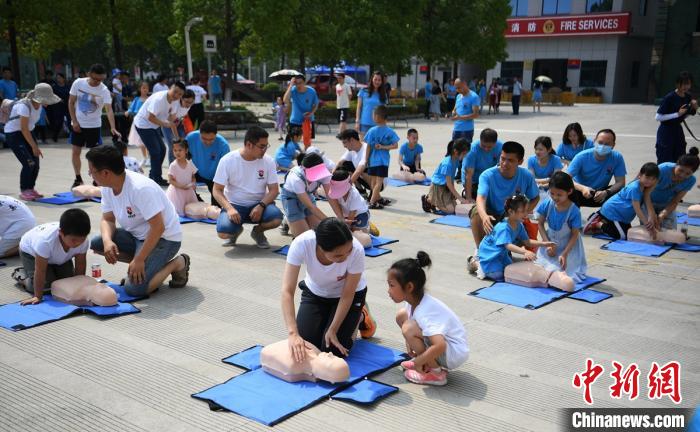 父母与孩子一起学习心肺复苏应急救援方法。　刘忠俊 摄